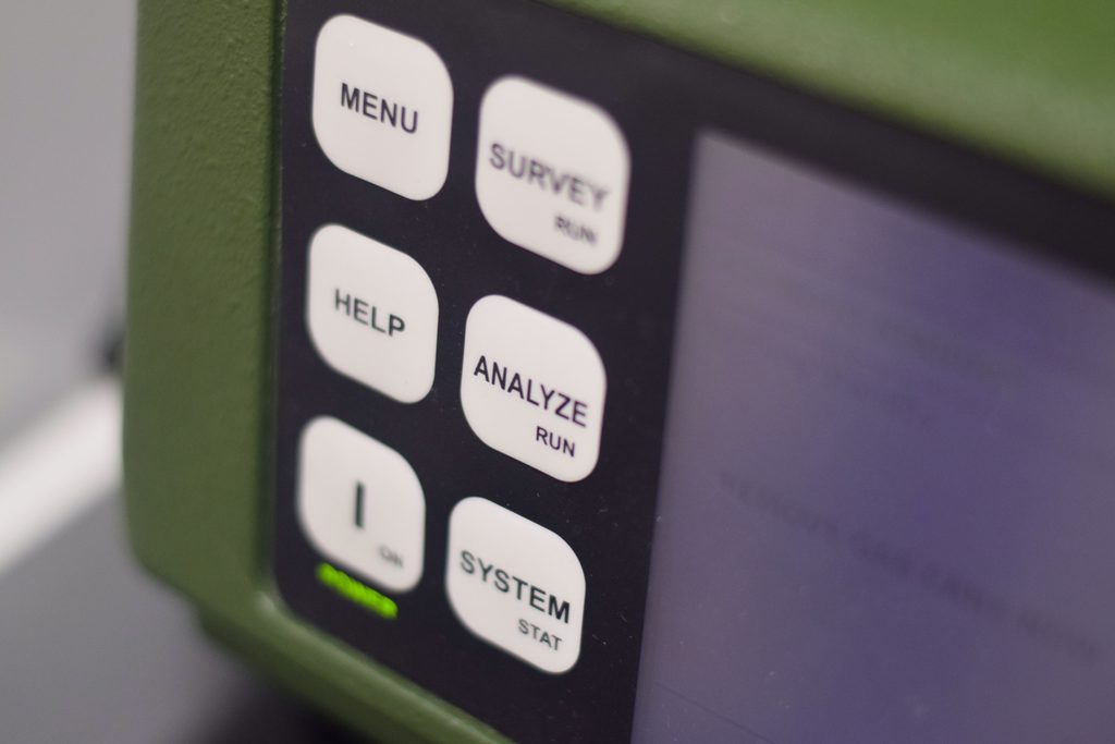 Grünes Messgerät, eine Taste mit Aufschrift "Analyze" ist im Fokus