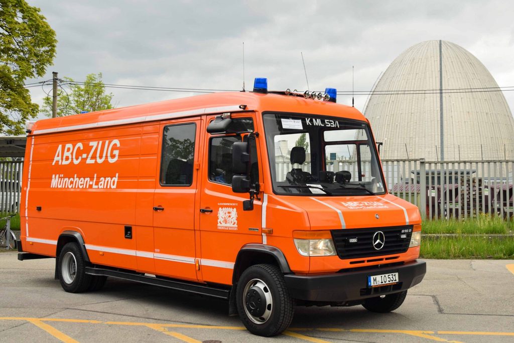 Bild des Gerätewagen Atemschutz-Strahlenschutz. Ein oranger Transporter, im Hintergrund das Garchinger "Atom-Ei".