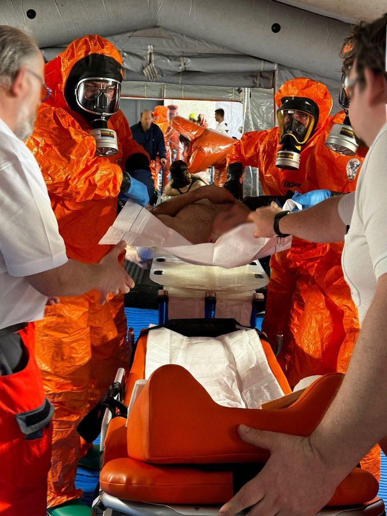 Eine verletzte Person wird liegend an den Rettungsdienst übergeben